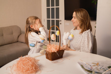 Mother and daughter enjoying Easter crafts and decorating in a cheerful home settingの写真素材