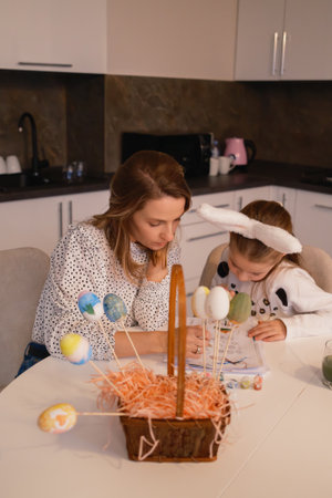Family decorating Easter eggs together in a cozy kitchen atmosphereの写真素材
