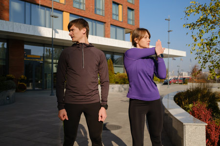 Couple stretching and preparing for a run in an urban outdoor setting