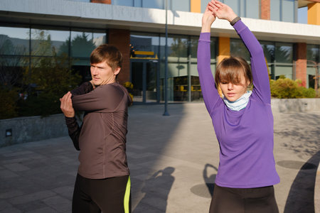 Couple stretching outdoors preparing for a jog in the morningの写真素材