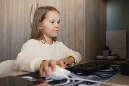 Young girl using a computer confidently in a cozy home environment