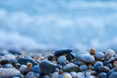Stones on the beach with blured sea water on a background.の写真素材