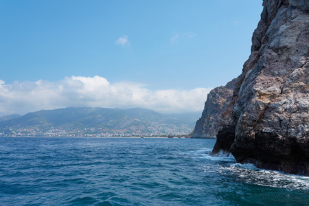 The coast of the sea. Beautiful cliffs over the blue, view from the sea. Clouds and mountains on the background. Alanya, Turkey.の写真素材