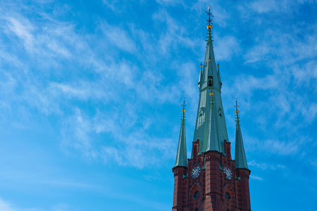 Clocktower of Cathedral in the old city of Stockholm against a blue cloudy sky. Copy space for text.の写真素材