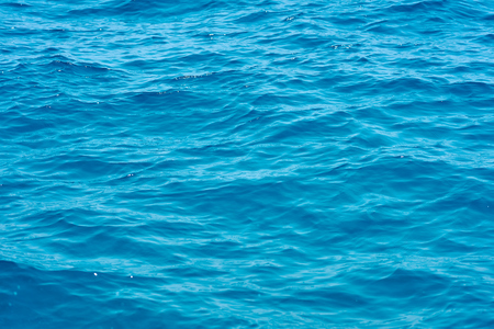 Waving clear blue sea water background.の写真素材