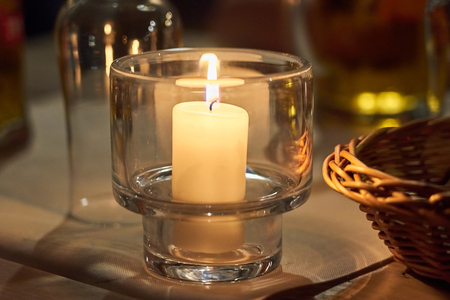 Candle on a table with blurred background bokeh.の写真素材