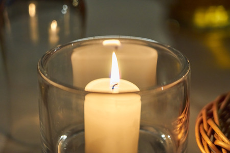 Candle on a table with blurred background bokeh.の写真素材
