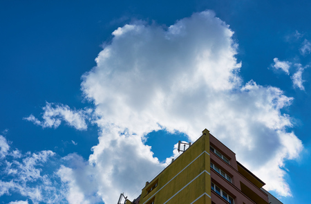 Top of apartment building against a blue cloudy sky as a natural texture.の写真素材