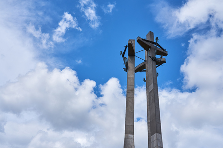 Three Crosses with anchors, a monument to the fallen workers of shipyard at Solidarnosti Square in Gdansk, Poland against a blue cloud sky. Copy space for text.のeditorial素材
