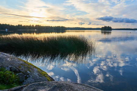 Sunset on the lake with cloudy sky on a background.の写真素材