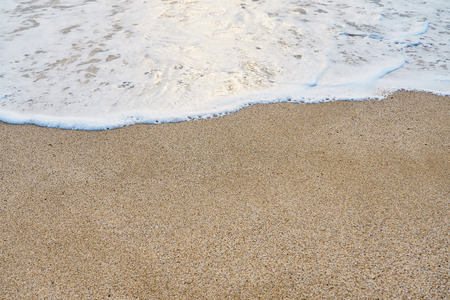 White foam on a sandy beach. Copy space.の写真素材