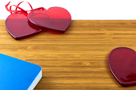 Red glass hearts on wooden background with notes book and copy space for text. ValentineÂ´s day concept.の写真素材
