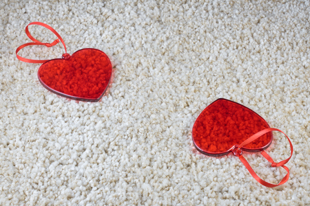 Red glass hearts on a carpet love and Valentine concept. Copy space.の写真素材