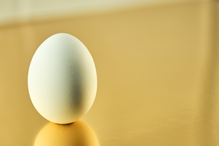 White egg with golden background. Easter concept.の写真素材