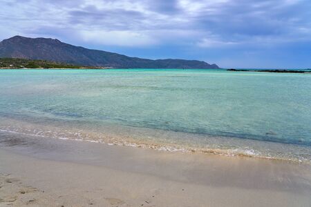 Tropical sandy beach with turquoise water under cloudy sky. Copy space.の写真素材