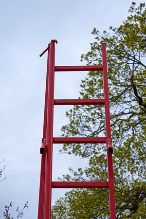 A red fire stairs outdoor with tree on a background. Fire escape.の写真素材