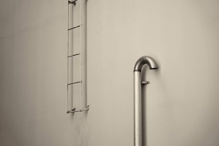 A fire stairs outdoors on a wall. Fire escape and ventilation pipe.の写真素材