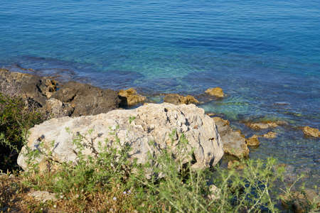 Stones on a sea coast of Colimbari, Crete, Greece against a blue sea water. Copy space.