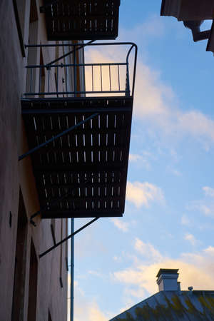 The walls of old houses with balconies and blue sky in the background.