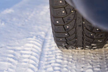 Winter wheel of the car with metal spikes. Copy space.