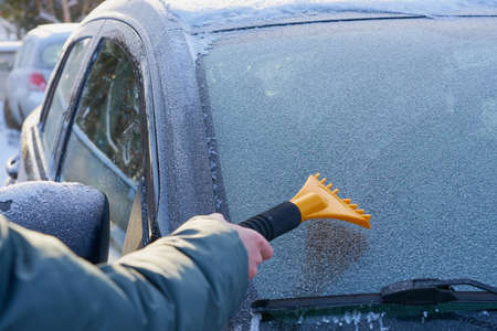 Cleaning the windshield of the car from the ice. Copy space.