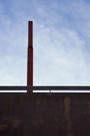 A metal pillar on a concrete bridge against the sky with space for text.の写真素材