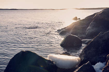 The stone coast of the Baltic Sea in spring with the remains of ice in sunlight.の写真素材