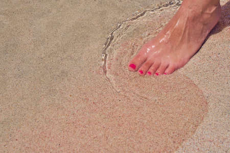 Leg of a white caucasian woman on a tropical Elafonissi beach with colorful sand in Crete Greeceの写真素材