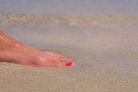 Leg of a white caucasian woman on a tropical Elafonissi beach with colorful sand in Crete Greeceの写真素材