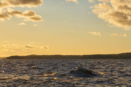Ripples from the waves on the surface of the water on the lake at sunsetの写真素材