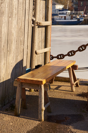 Wooden bench by the barn on the bank of the river.