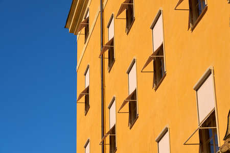 A yellow multi-storey building with a blue sky in the background.の写真素材