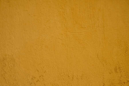 The painted wall of the old house is yellow painted as a background.の写真素材