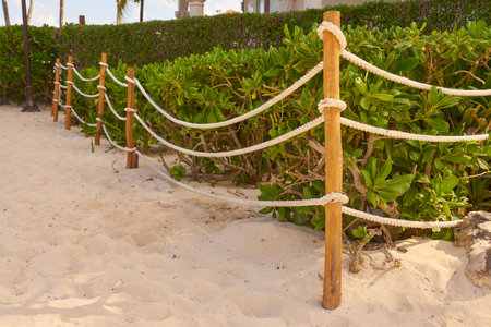 A fence of boards and a rope in the sand.の写真素材