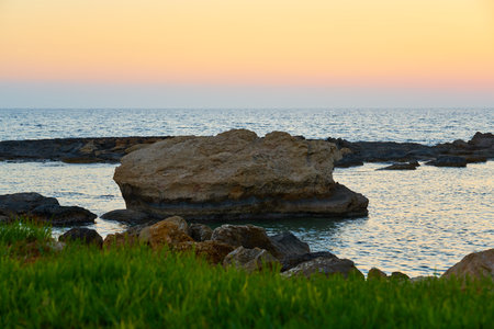 A colorful sunset on the rocky Mediterranean coast.の写真素材