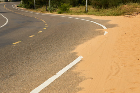 Desert sand steps on an asphalt road.の写真素材