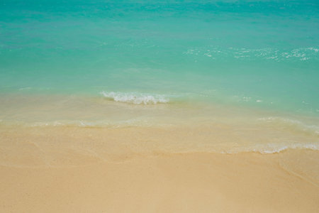 Waves and foam on a tropical sandy beach.の写真素材