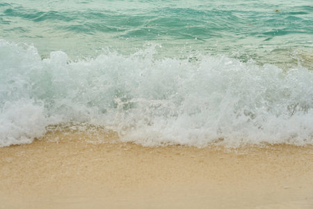 Waves and foam on a tropical sandy beachの写真素材