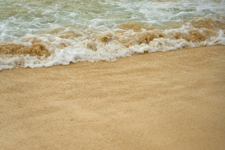 Waves and foam on a tropical sandy beach.