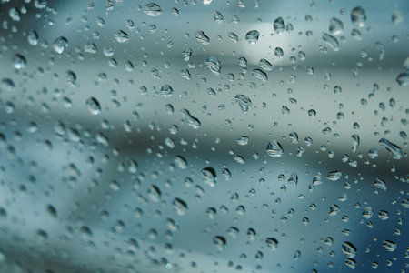 Raindrops on glass with blurred background