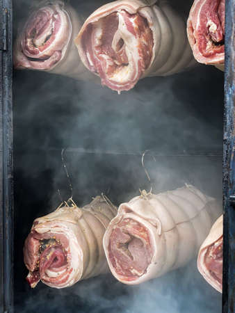 Spiced rolled meat being roasted in smokeの写真素材