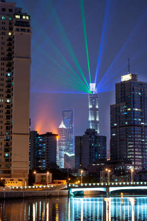 Shanghai, China - 04/11/2019: Shanghai light show at night to international import and export expo ciie 2019 with residential buildings in the foreground and skyscraper in the background colorfulのeditorial素材