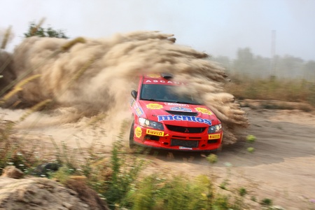 Ukraine. Kiev. The fifth stage of the championship of Ukraine "Alexandrov Rally" - 15.08.2010 Salyuk Alexander, Jr. and Evgeniy Chervonenko on the car Mitsubishi Evo 9. The race in difficult conditions, very hot and dusty. The red car is goes along a dustのeditorial素材