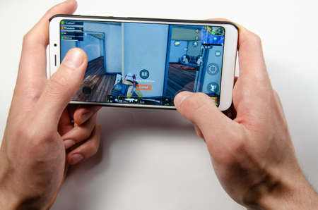 April, 2019. Kramatorsk, Ukraine. The gameplay of the game PUBG G Mobile on a white smartphone in handのeditorial素材