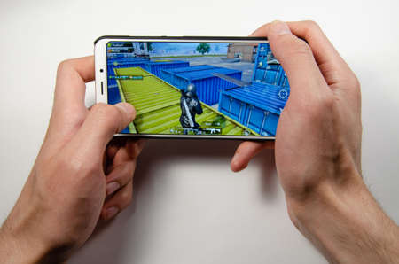 April, 2019. Kramatorsk, Ukraine. The gameplay of the game PUBG G Mobile on a white smartphone in handのeditorial素材