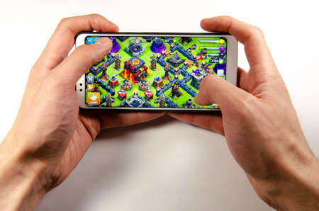 April, 2019. Kramatorsk, Ukraine. Clash of Clans gameplay on a white smartphone in handのeditorial素材