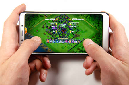 April, 2019. Kramatorsk, Ukraine. Clash of Clans gameplay on a white smartphone in handのeditorial素材