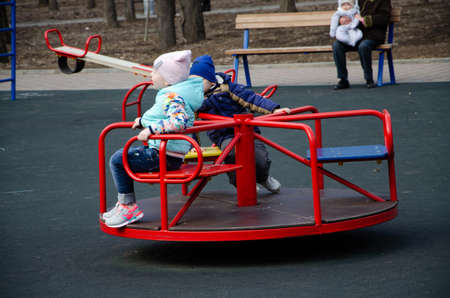 Mom plays on a bright playground with a small child in the street, nomads, a house during the dayのeditorial素材
