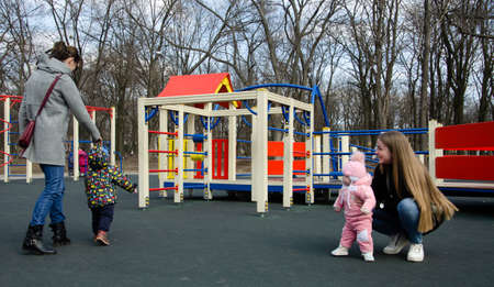 Mom plays on a bright playground with a small child in the street, nomads, a house during the dayのeditorial素材