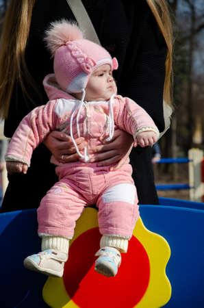 Mom plays on a bright playground with a small child in the street, nomads, a house during the dayの写真素材